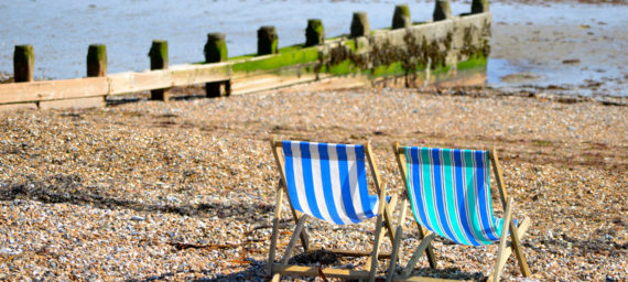 Deckchairs on pebble beach.